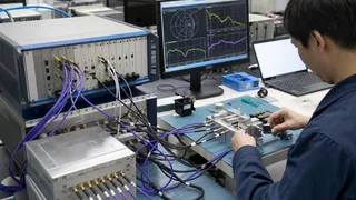 Engineer connecting a production RF fixture to a PXIe vector network analyzer bench